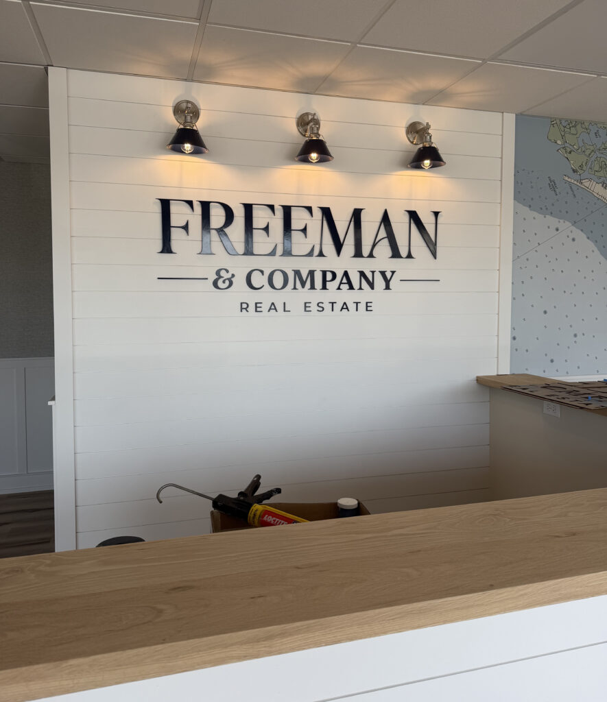 Freeman & Company Real Estate dimensional lobby logo sign installed on an interior feature wall